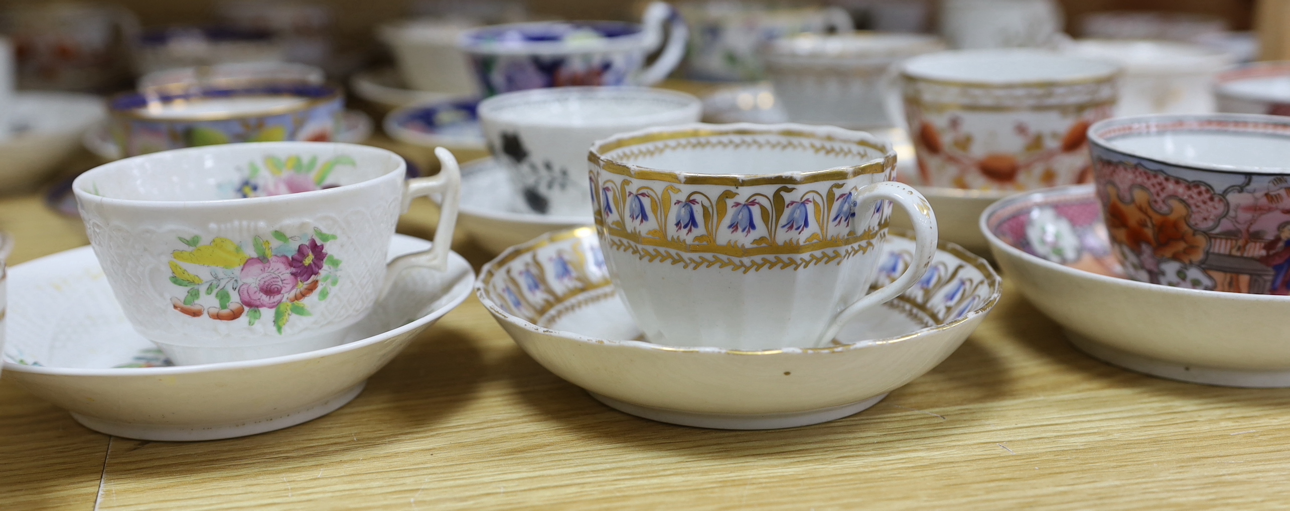 Collection of 18th/19th century English porcelain tea and coffee cups, bowls and saucers, some with hand painted and gilded decoration, the largest 15cm in diameter